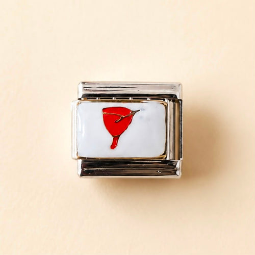 A square Italian charm link with a white enamel face featuring a red menstrual cup design, set in a polished silver-tone metal frame, on a light beige background.