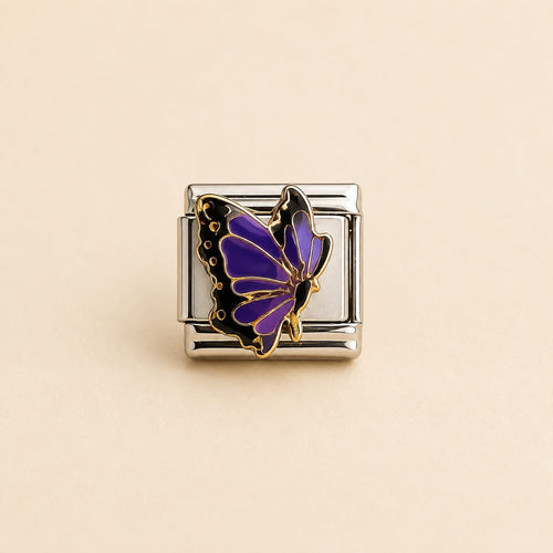 A silver-toned rectangular charm link featuring a purple and black butterfly with gold outlines, set against a solid beige background.