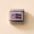 A rectangular charm link with a lavender purple face, featuring a gold-tone ring icon and the text 'Bling Bling' in black with a gold outline, set in polished silver-tone metal on a light beige background.
