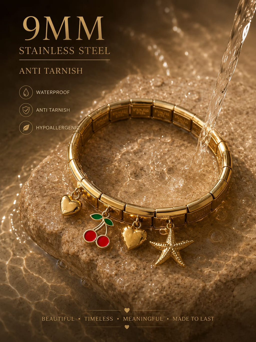 A gold-toned stainless steel charm bracelet with segmented links, shown on a stone surface with water flowing over it. The bracelet has three dangling charms: a heart, a starfish, and cherries with red and green enamel details.