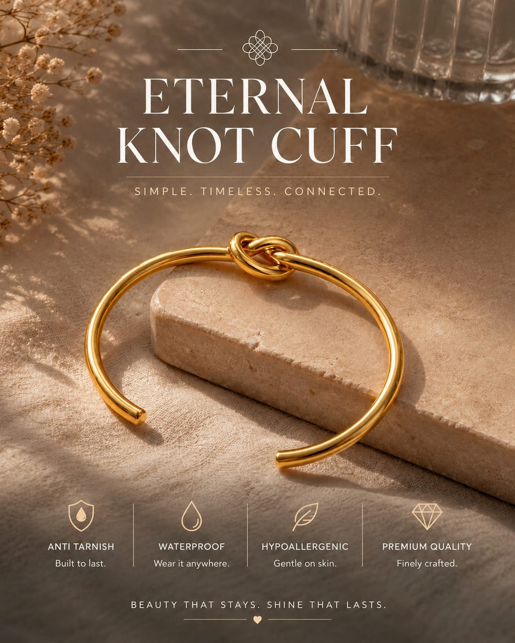 A gold-toned open cuff bracelet with a knotted center detail, displayed on a stone slab with decorative dried flowers and a glass in the background. Large text reads 'ETERNAL KNOT CUFF' with smaller feature callouts along the bottom.