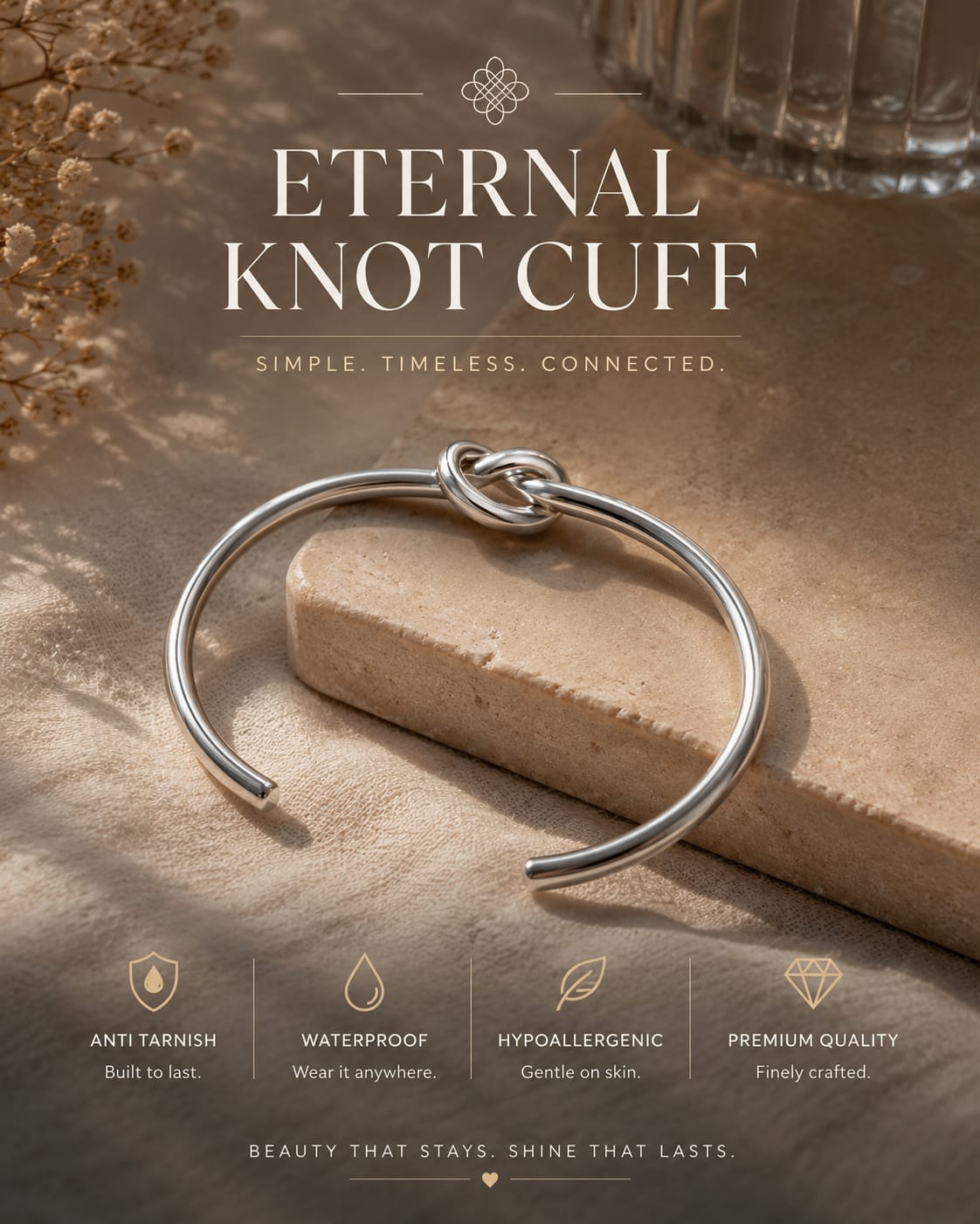 A silver-toned open cuff bracelet with a knotted center detail, displayed on a stone slab with text reading 'ETERNAL KNOT CUFF' and feature callouts below.