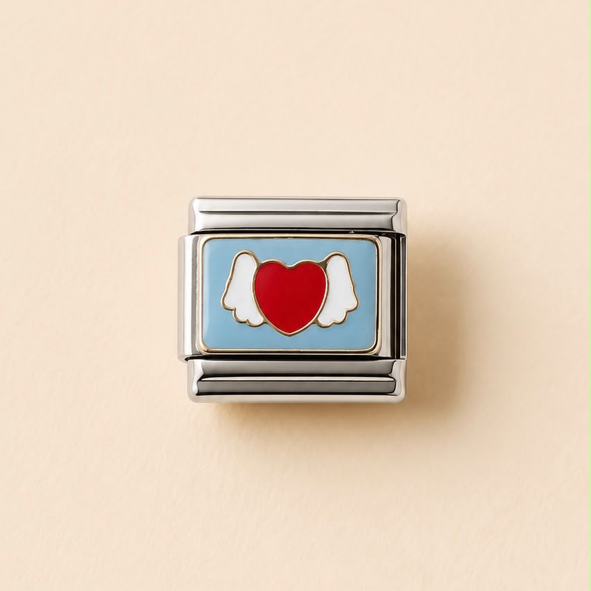 A rectangular silver-tone charm link featuring a light blue enamel background with a red heart and white angel wings, centered on a warm beige background.