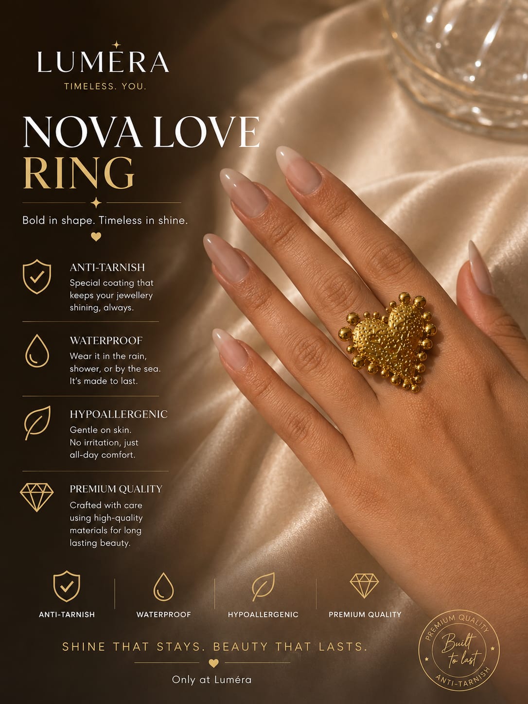 A hand wearing a large gold heart-shaped ring with textured details, set against a luxurious champagne-colored satin fabric background. The left side of the image features a dark brown informational panel with text detailing the features of the LUMÉRA Nova Love Ring.
