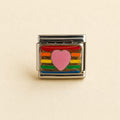 A rectangular silver-toned charm link featuring a pink heart in the center, surrounded by horizontal rainbow stripes in red, orange, yellow, green, and blue, set against a light beige background.