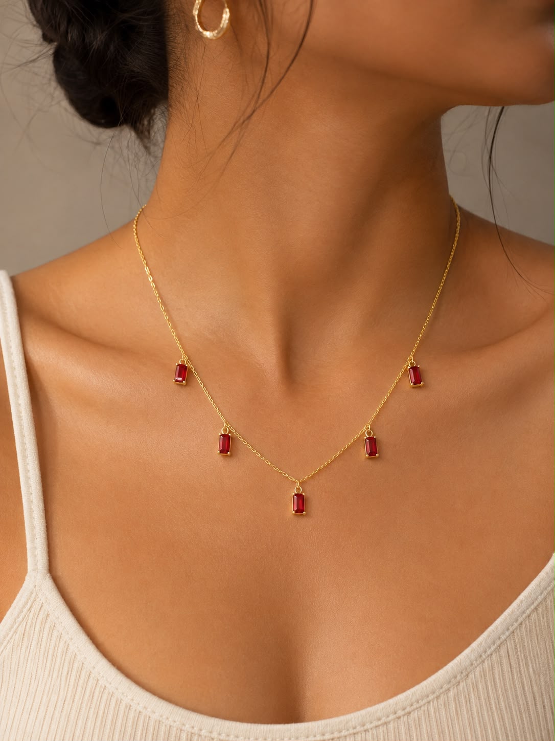 eye-catching, the Ruby Rain Necklace features five sparkling ruby-red baguette crystals delicately suspended from a fine gold-tone chain. Its minimalist silhouette adds the perfect pop of color, making it an effortless accessory for both everyday elegance and special occasions. Lightweight, timeless, and easy to style, it's a must-have addition to every jewelry collection.