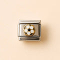 A square silver-toned metal charm link featuring a soccer ball motif in the center with white and black pentagons outlined in gold, set against a solid pale peach background.
